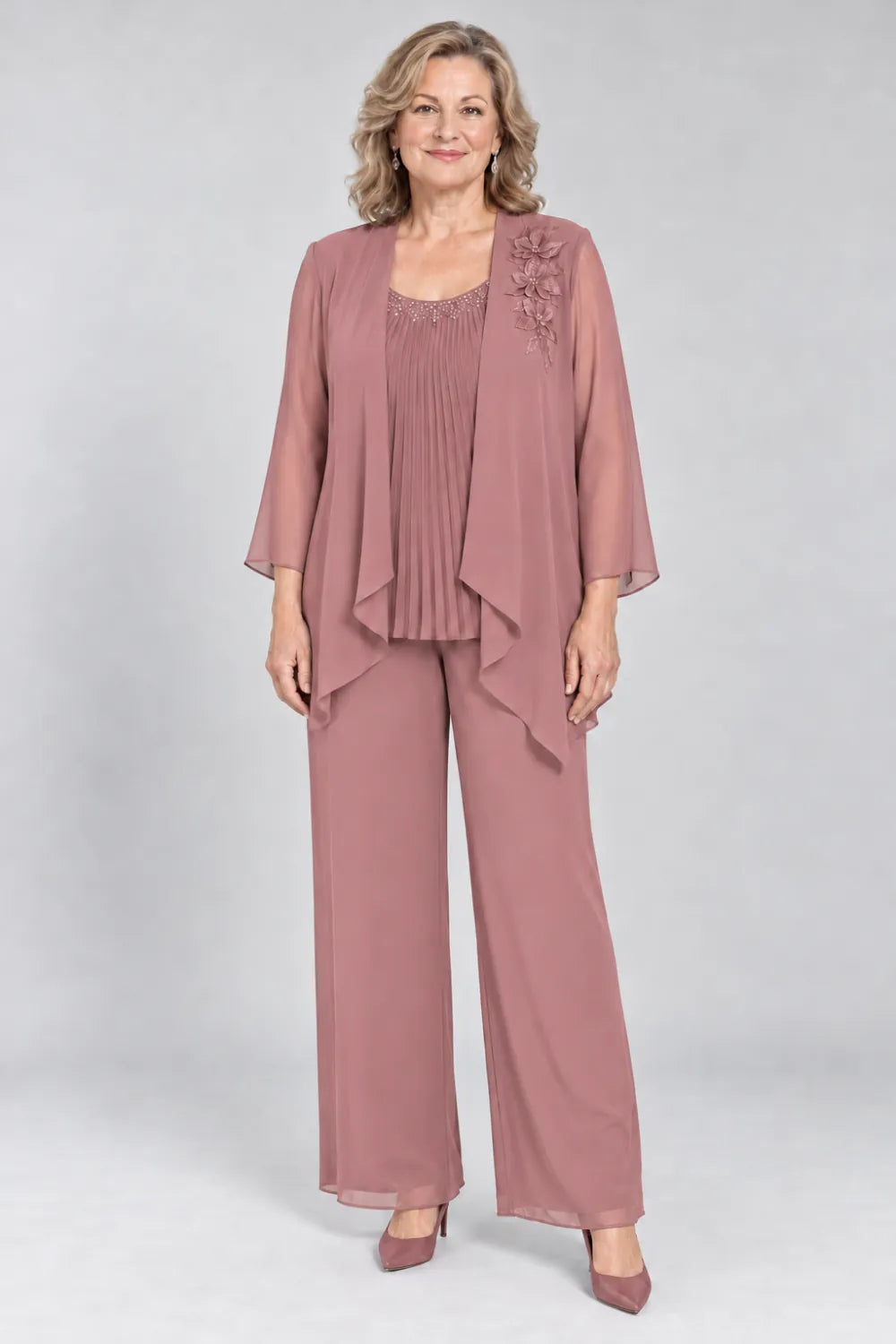 Dusty Rose pant suit with fine pleats, decorated neckline and floral shoulder motif, front view.