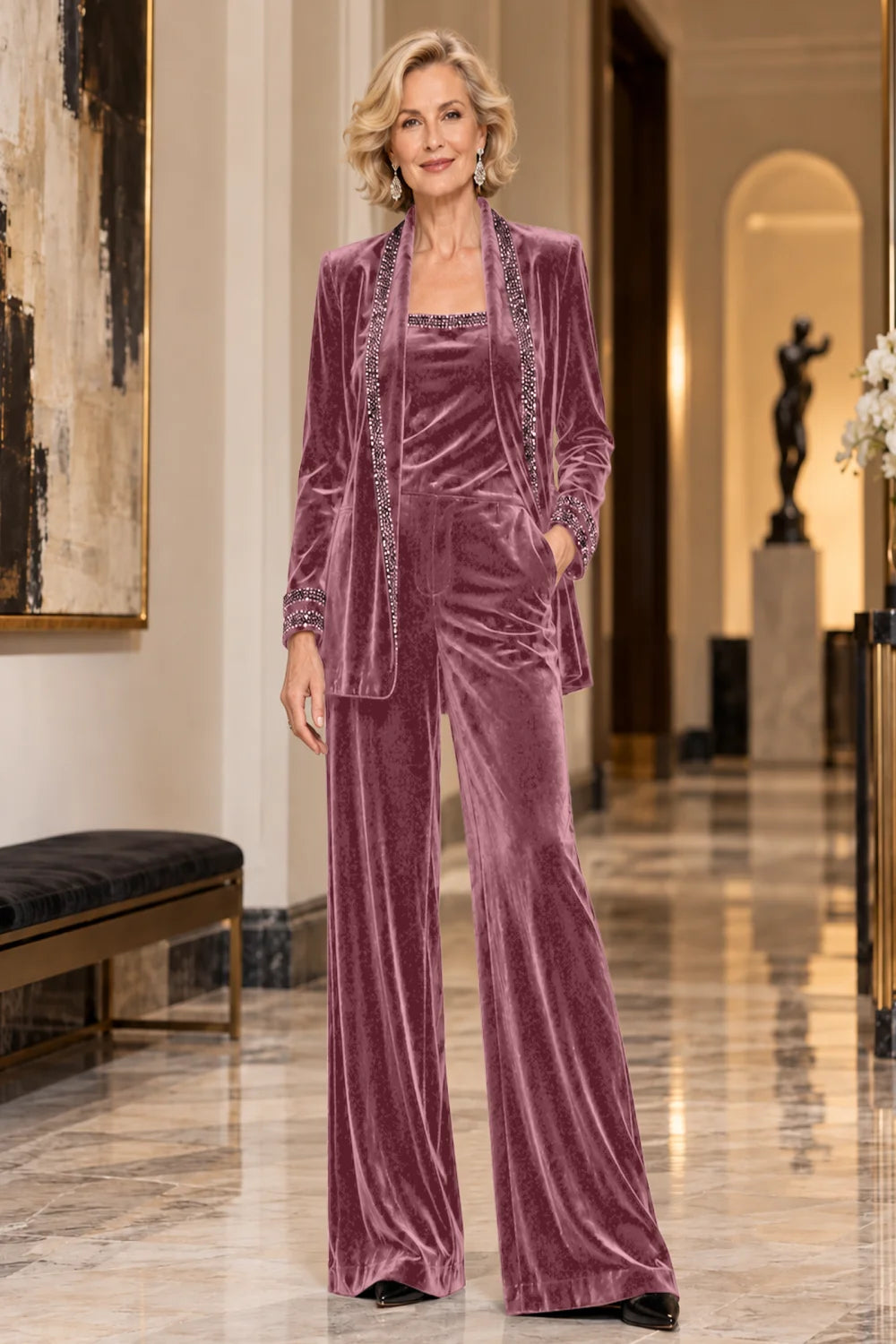 Front view of a dusty rose pant suit with a trimmed jacket, matching top and wide-leg trousers.