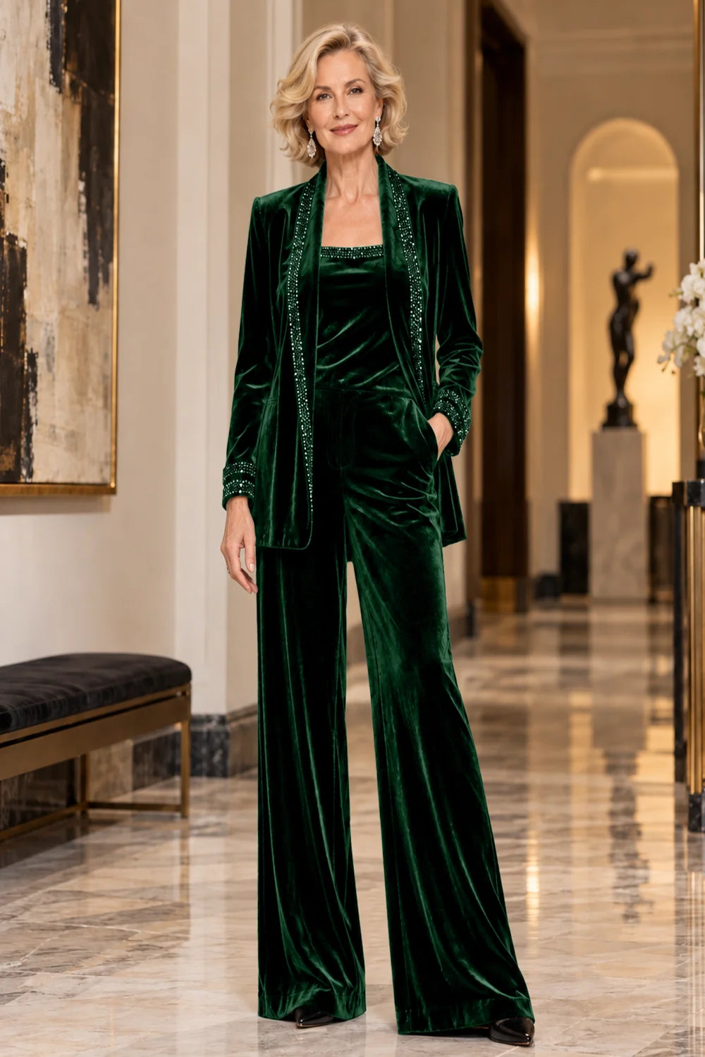 Front view of a emerald green pant suit with a trimmed jacket, matching top and wide-leg trousers.