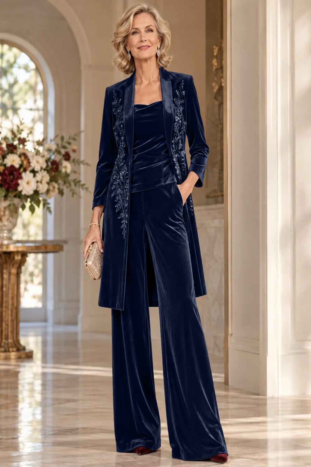Front view of a navy blue pant suit with a floral-trimmed long jacket and wide-leg trousers.