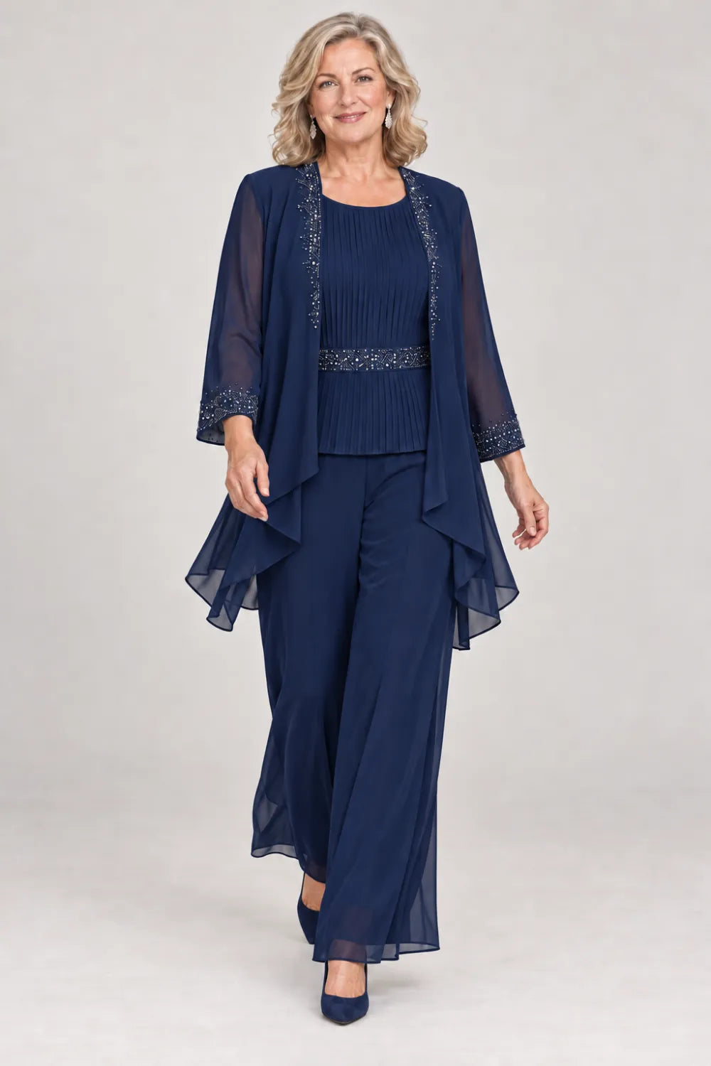 Navy Blue pant suit with pleated top and beaded waist, jacket edges and cuffs, front view.