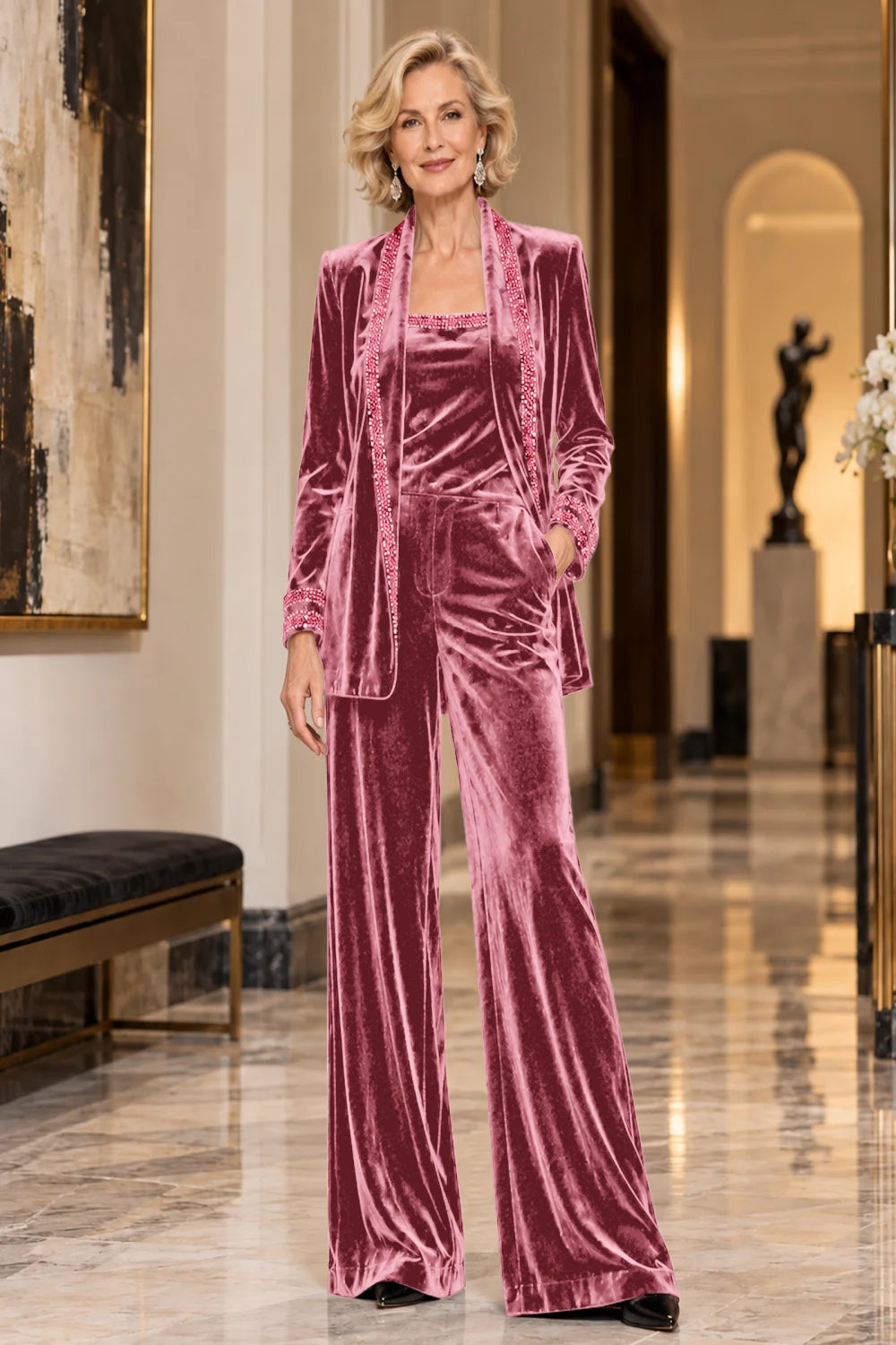 Front view of a pink pant suit with a trimmed jacket, matching top and wide-leg trousers.