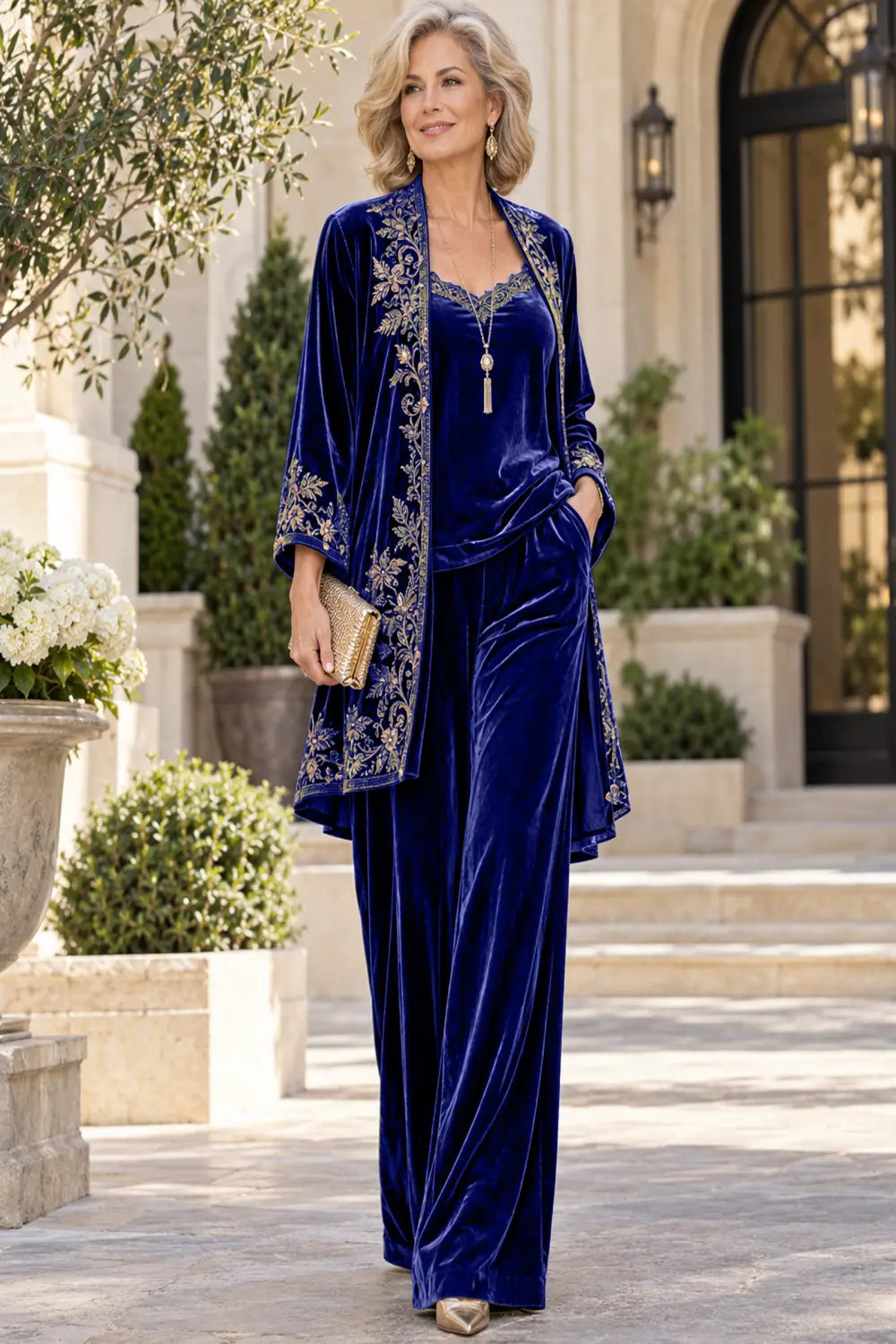 Front view of a royal blue pant suit with a floral-bordered long jacket and matching trousers.