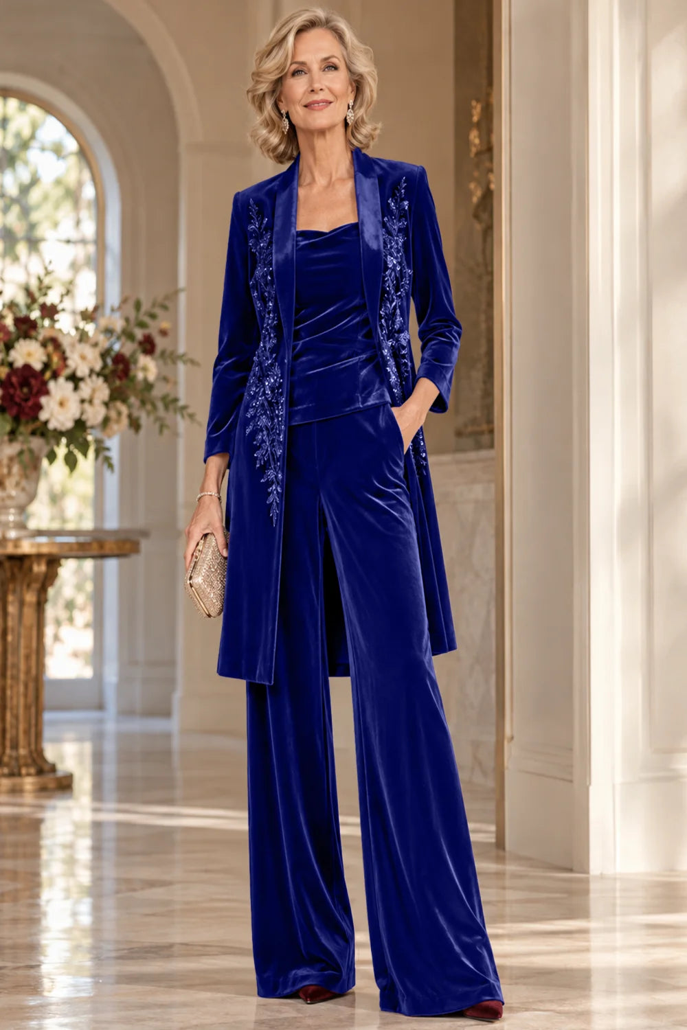 Front view of a royal blue pant suit with a floral-trimmed long jacket and wide-leg trousers.