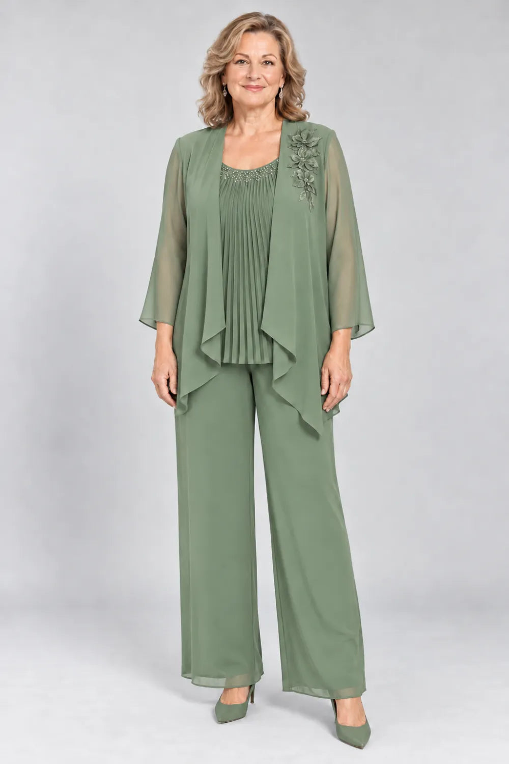 Sage Green pant suit with fine pleats, decorated neckline and floral shoulder motif, front view.