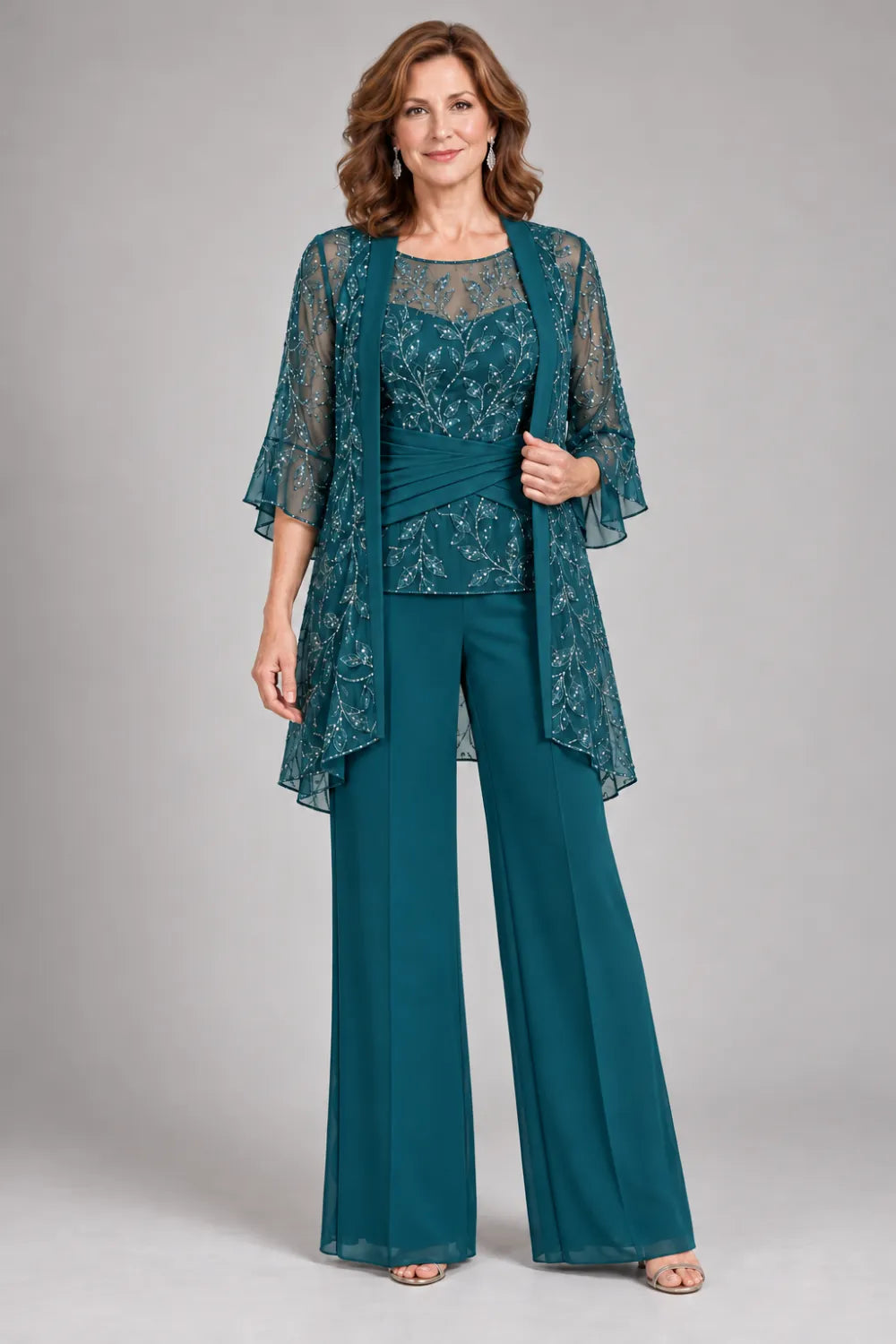 Teal pant suit with floral lace top and diagonal gathered waist, front view.