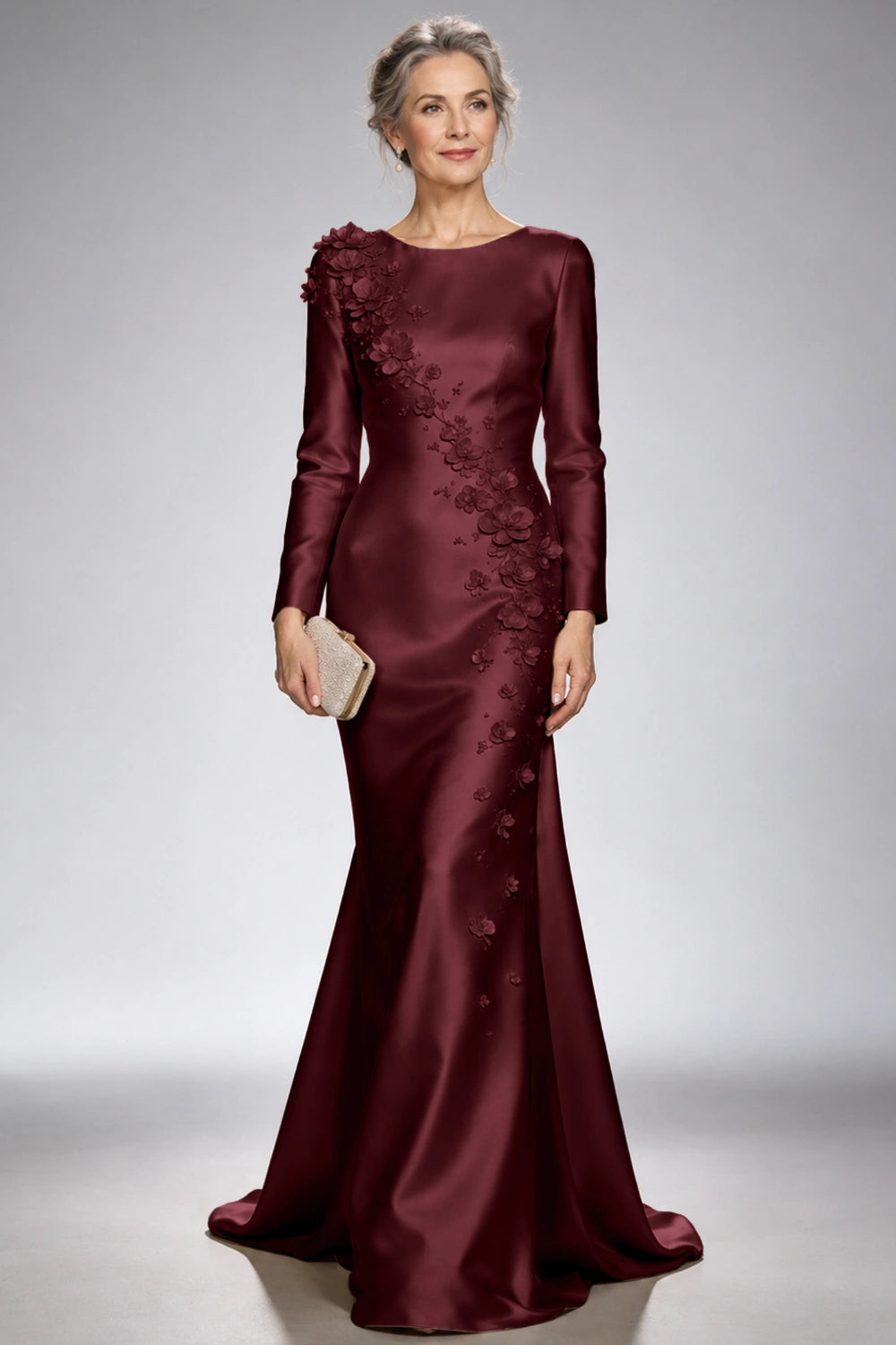 Front view of the burgundy satin mermaid dress with long sleeves and diagonal floral appliques across the bodice and skirt.