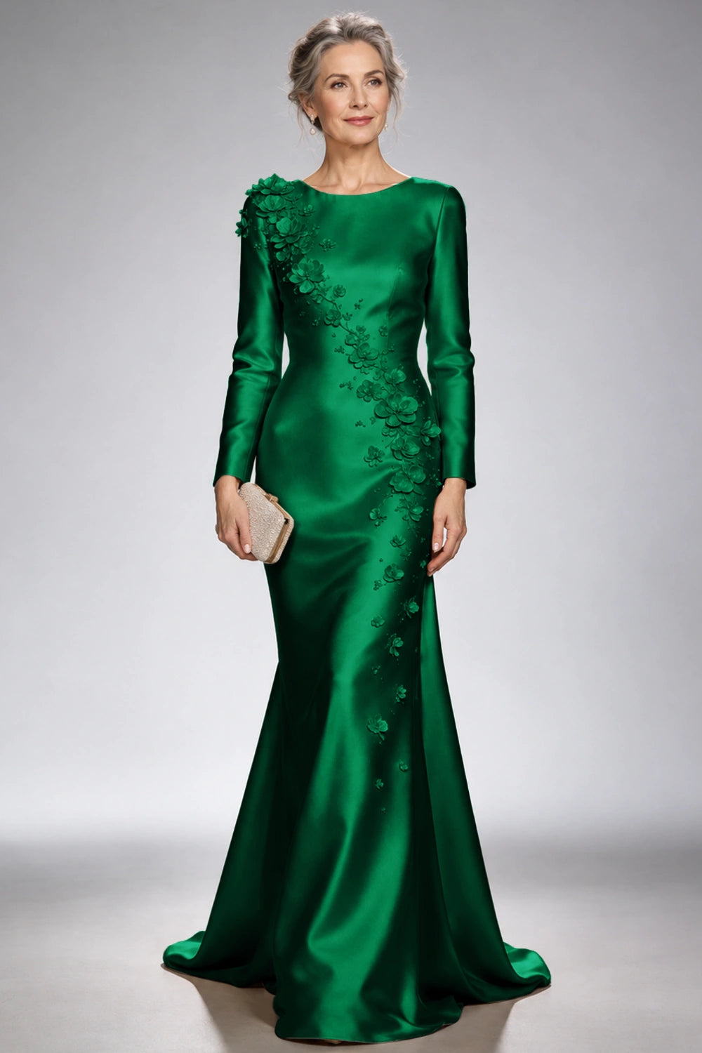 Front view of the emerald green satin mermaid dress with long sleeves and diagonal floral appliques across the bodice and skirt.