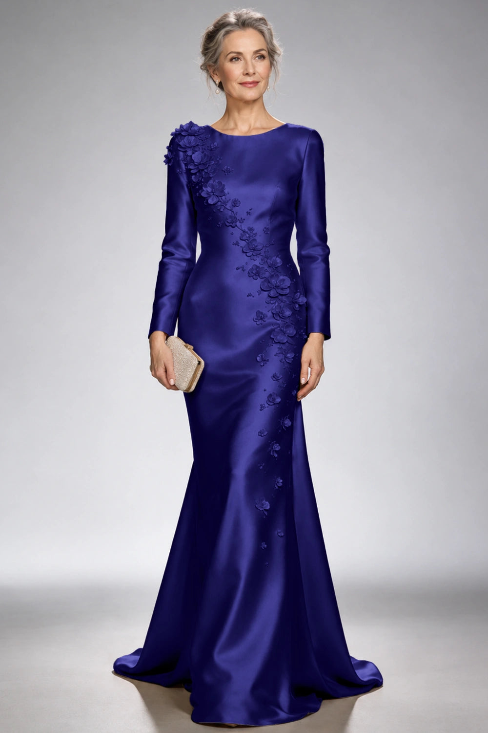 Front view of the royal blue satin mermaid dress with long sleeves and diagonal floral appliques across the bodice and skirt.